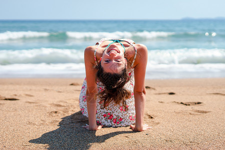 卫生保健夏天穿着衣服的年轻女子在海边滩做瑜伽在阳光明媚的白天正念女士图片