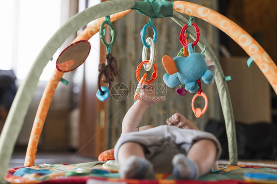 背部俏皮甜的使用移动式教育玩具在开发地毯中放置运动式教育玩具图片