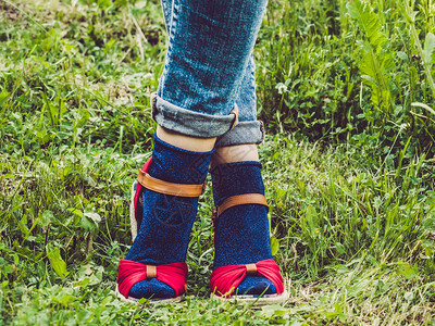 年轻的牛仔裤红色在绿草时装和美容的风格概念时装和美观鞋子和亮袜的背景下女方双腿时装鞋和亮袜子图片