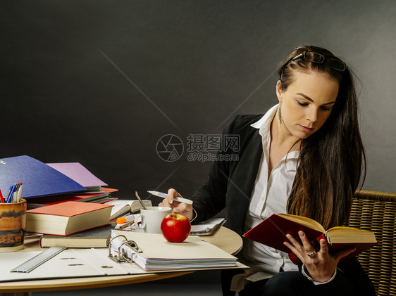 一种照片来自位教师或女商人她的30rsquos坐在桌子前的大黑板阅读台前商业头发图片