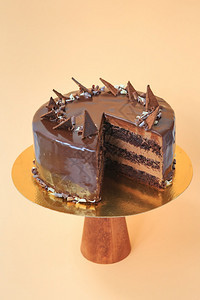 为了层糖在木蛋糕摊子上切了生日蛋糕美丽的巧克力海绵蛋糕鲜奶油黄色背景复制空间食物摄影作为谱图片