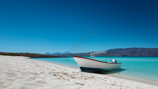 墨西哥PlayaIslaCoronado带有白沙松绿海和蓝天的堂滩汽车船蓝色的旅行绿图片