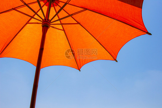 橙子遮阳板阴凉处橙色海滩保护伞由木制成用于保护有亮蓝天空背景的阳光图片