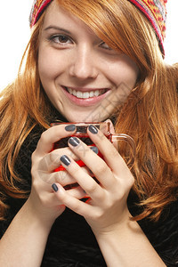 青年轻快乐的红发女人穿着冬装端茶穿冬装端茶的年轻快乐红发女人马克杯帽子图片
