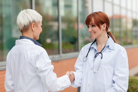 两位女医生在户外握手的照片来自两名女医生成功的职员医疗图片