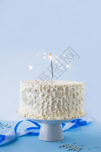 散景磨砂白生日蛋糕上面有燃烧的火花高分辨率照片白生日蛋糕上面有燃烧的火花食物图片