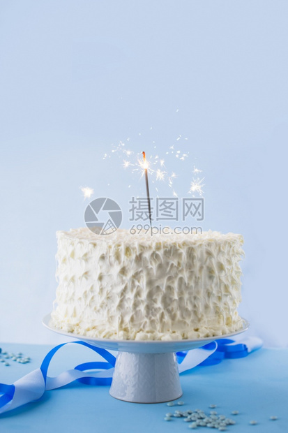 散景磨砂白生日蛋糕上面有燃烧的火花高分辨率照片白生日蛋糕上面有燃烧的火花食物图片