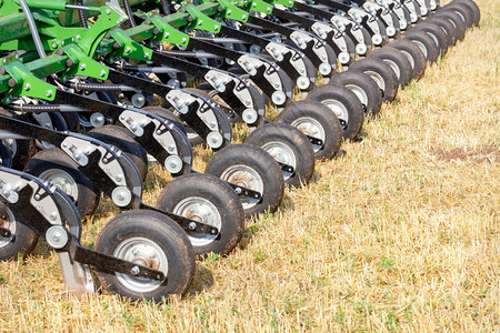 农业综合企技术在阳光明日的农业田地背景上一排充气轮用多行平板管道挂在多行平台上的输气管在一个农业田地的背景上复制空间接近一个农业图片