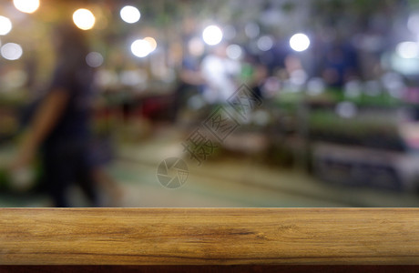 餐厅购物中心和步行者面对抽象模糊背景的餐饮商场和行走时空黑木桌可以用来展示或装饰你的产品图像模糊的硬木散焦图片