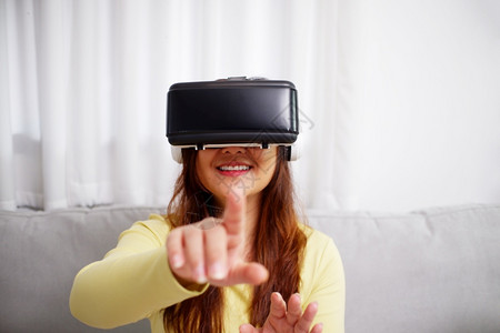 戴着VR头盔触摸的女性图片