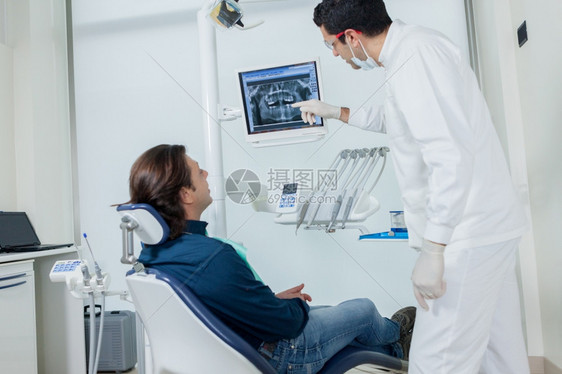 牙医在监视器上向病人展示他的打算怎么做清理从业者电脑图片
