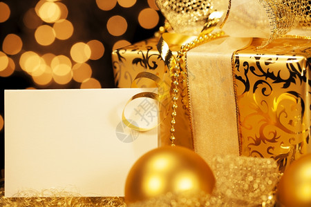 奢华闪亮的带圣诞球金色礼物带球和礼品卡的金色圣诞礼物子图片
