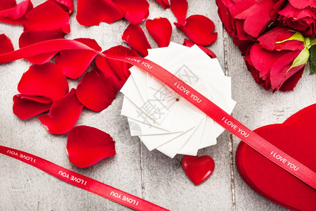 象征赠品盒红玫瑰和花瓣在木制桌子上的照片问候浪漫图片
