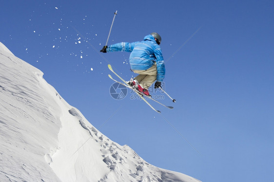 冬季雪山跳跃的滑雪者图片