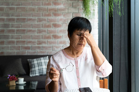 使用智能电话保健概念的老妇女头痛症陈年讲话图片