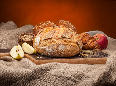 白色的不同种类新鲜面包以小麦和水果为背景的新鲜面包不同类型的新鲜面包多于烘烤的图片