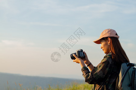 美丽的移动在日出海边山峰拍摄照片时观看的有背包女亚洲景观图片