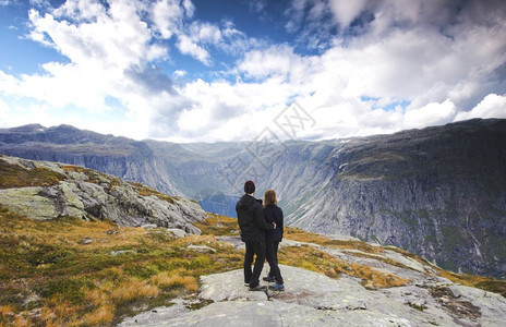 著名的爬坡道一对游客站在令人惊叹的景色美丽自然景观在挪威Trolltunga斯堪的纳维亚蓝天徒步旅行一对游客站在令人惊叹的景色美图片
