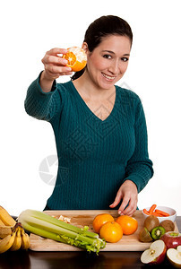 厨师白色的快乐美丽女士展示一个美味的有机皮橙子水果厨房里满了维他命C摄影图片