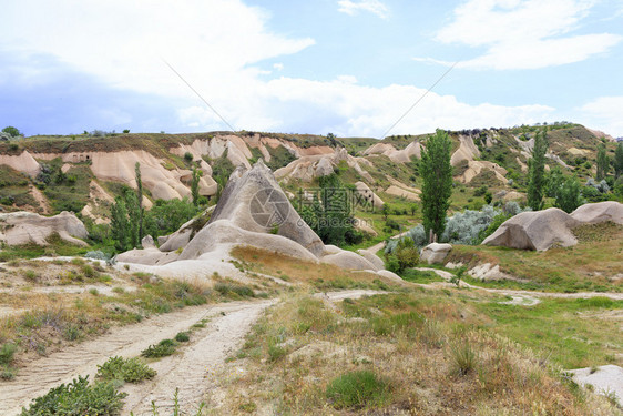 乡村的爬坡道穿过古老峡谷地的泥土路和废弃卡帕多西亚山洞古老峡谷的Capapadocia景观以及被弃的卡帕多西亚山洞蓝色的图片