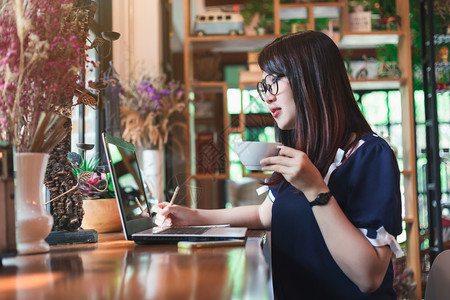亚洲女商人像背景一样在咖啡店里用笔记本电脑工作一起喝咖啡家沟通吸引人的图片