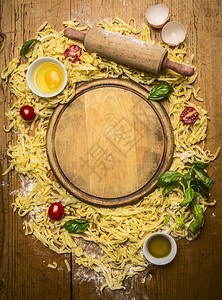 食谱黄色的以木制生锈背景最佳视野环绕切割板的意大利面粉鸡蛋滚针草药叶子油意大利语图片