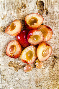 多汁的新鲜白木桌上切片黄樱桃准备用于烹饪的切片黄色樱桃在白木桌上切黄樱桃明亮的图片