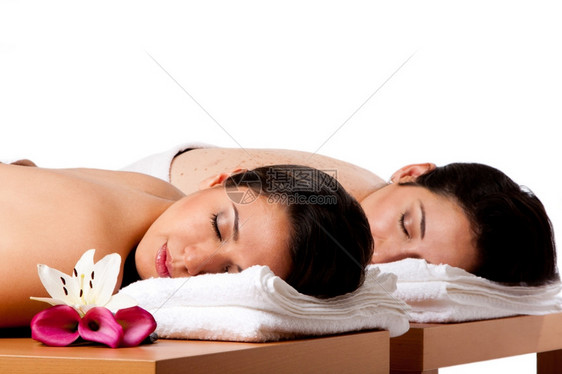 睡觉两名美丽的女朋友躺在木桌上头戴毛巾在温泉水里等待按摩被隔离团结为了图片