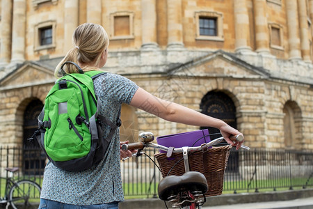 英国拉德克利夫广场骑着旧式自行车的女学生背影图片