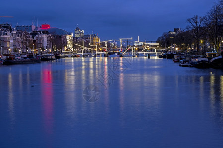 建筑学路阿姆斯特丹市位于阿姆斯特尔河日落时在荷兰有受污染的薄度桥首都图片
