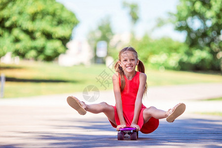 时尚可爱的小女孩在夏日公园里玩滑板得开心可爱的孩子在夏日公园里玩滑板冰年轻的图片