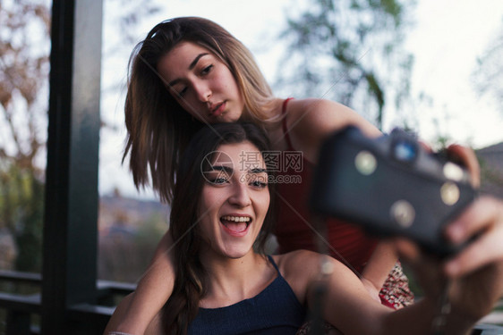 两个女青年晚上在阳台拍自模拟快乐的自然图片