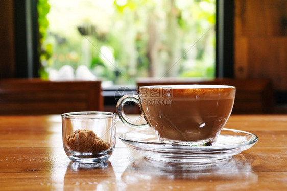 蒸汽克丽玛咖啡杯热木制桌上的甘蔗糖杯窗口视图咖啡店图片