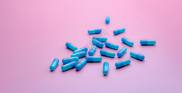 传播于粉红背景的蓝色抗生素胶囊药丸物医业保健和学概念卫生预算Capsule制造业保健和医疗治超级细菌蓝色的图片