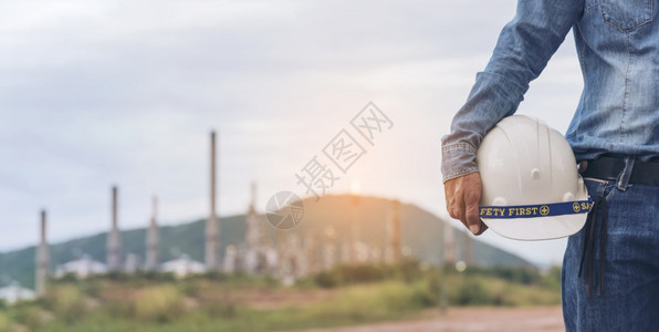 生产工人解构匠手持土建程筑长身着安全西装在建筑工地手上戴白色作头盔硬帽的匠手掌上架有白工作头盔图片