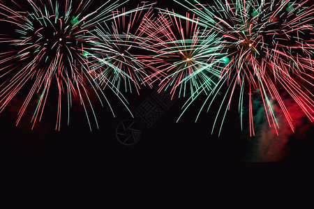 七月黑暗背景的烟花抽象摘要在夜空新年庆祝节天空上进行彩色烟花在黑背景和免费文本空间下制作黑背景的烟花派对自由图片