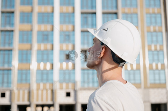 行业建筑工地人的画像建筑地戴头盔的漂亮工人画像建筑地人的画像面机械图片