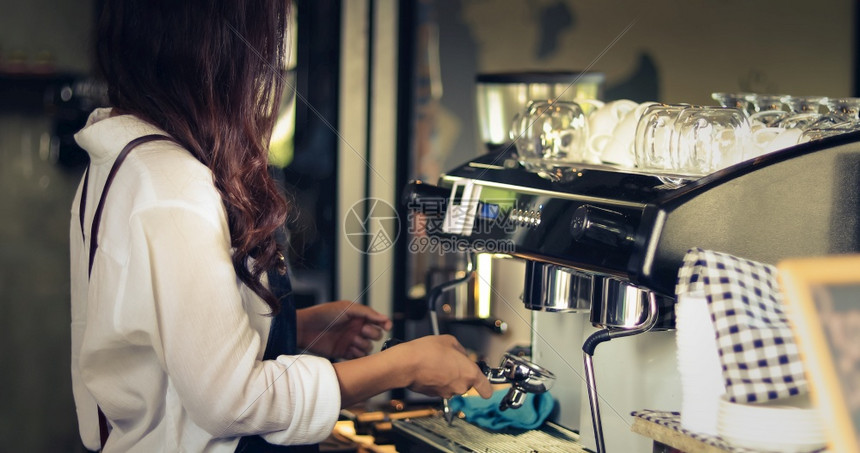 餐厅在咖啡店柜台微笑和使用咖啡机的工作妇女小业主店餐饮咖啡厅概念亚洲女律师协会职员服务图片