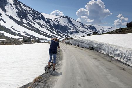 妇女拍摄了Gamlestrynefjellsvegen公路上雪的照片这是夏季诺瓦市最美丽的有雪汽车道路之一女士自然旅行图片