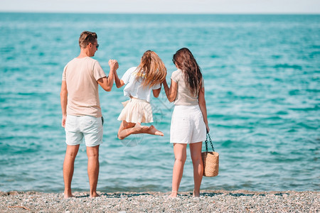 热带沙滩上度过暑假的幸福美满家庭图片