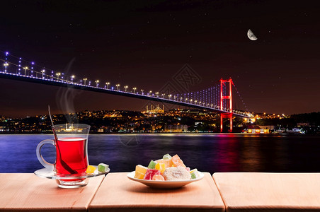 观光博斯普鲁海峡夜间发光的Bosphorus桥和传统土茶伊斯坦布尔传统的图片
