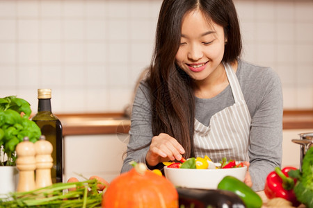 美丽的照片来自亚洲年轻女在厨房的家中制作多彩色沙拉快乐的切割图片