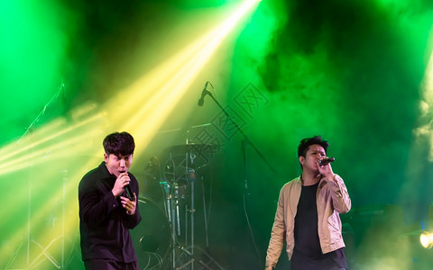两个亚洲歌手在舞台上表演配有多彩的现场亮光音乐会和娱概念笑声岩石丰富多彩的艺术家图片