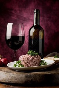 木制桌上红酒和美味意大利面条的照片墙红色烩饭图片