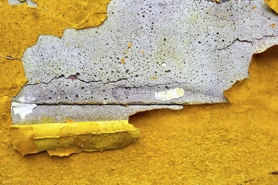 石膏材料破碎的混凝土墙有黄色橙剥皮涂漆旧破碎损坏的粗糙亮光背景纹理图片