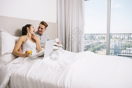 一对夫妇在清晨拥抱着欢笑的床早晨偎帅哥图片