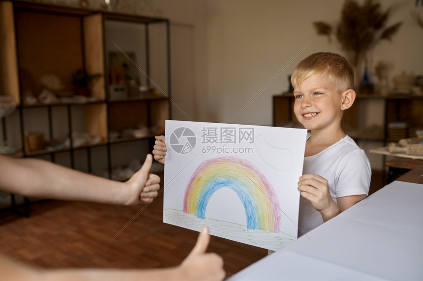 铅笔画小男孩展示他的绘画小男孩在艺术学校年轻画家愉快的爱好乐童年发展创意造的小男孩展示他绘画孩子在讲习班上展示调色板图片