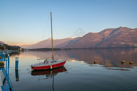 日落时分在阿尔卑斯山壮丽的湖上色彩缤纷的红船意大利伦巴第区洛韦雷市的伊塞奥湖全景贝加莫云放松图片