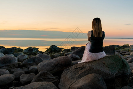 自由发型蓝色的拉脱维亚波罗海图贾市带岩石和女孩的海滨图片