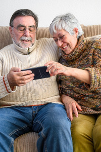 成熟Covid19待在家里快乐的退休老年夫妇用手机进行家庭视频通话社交距离积极的表达Covid19快乐的退休老年夫妇积极的表达妻图片